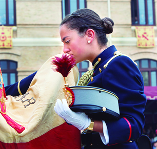 A lady cadet kisses the Flag with emotion